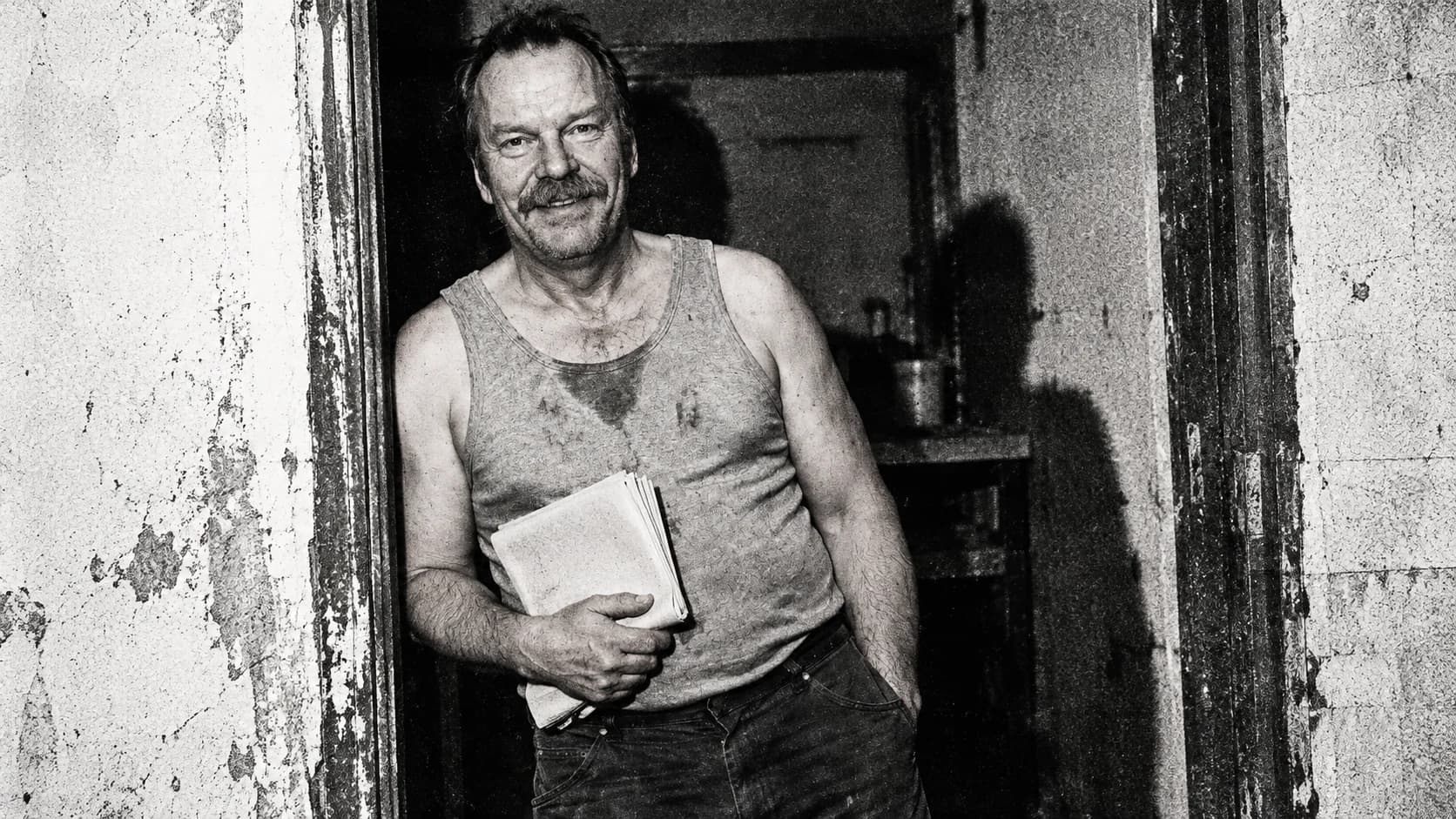 A doorway portrait of Brutalisti holding blank folded paper, reproduced with stark black photocopy texture.